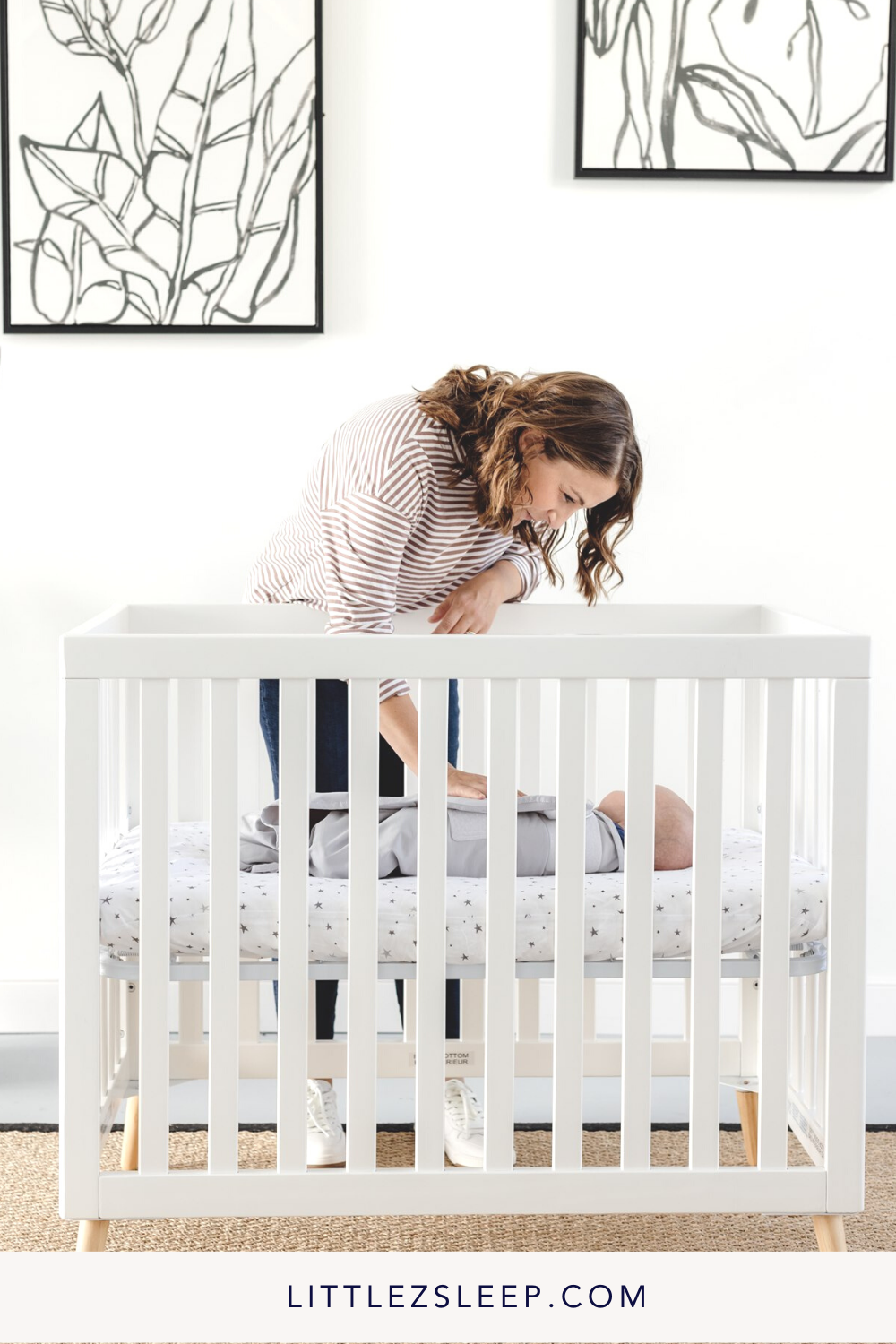 Mom putting her newborn down in their crib for a nap